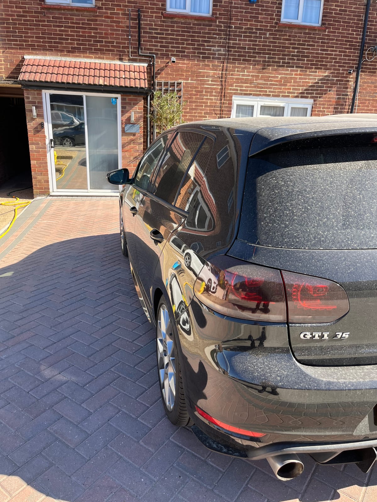 The same Golf GTI before detailing, rear quarter heavily spotted with dried water marks