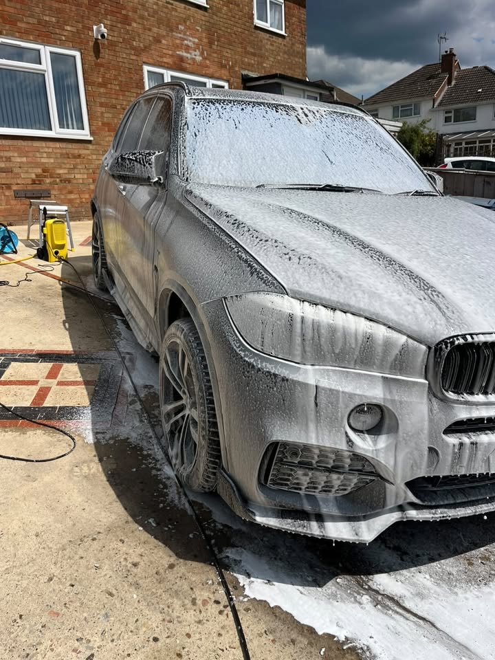 BMW X5 covered in snow foam during an exterior wash